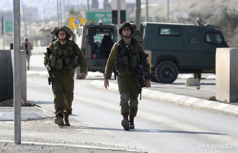 Israeli soldiers lead a stripped, blindfolded and handcuffed Palestinain youth to the back of the Huwara checkpoint after they suspected he was carrying explosives along with another boy near the West Bank city of Nablus...