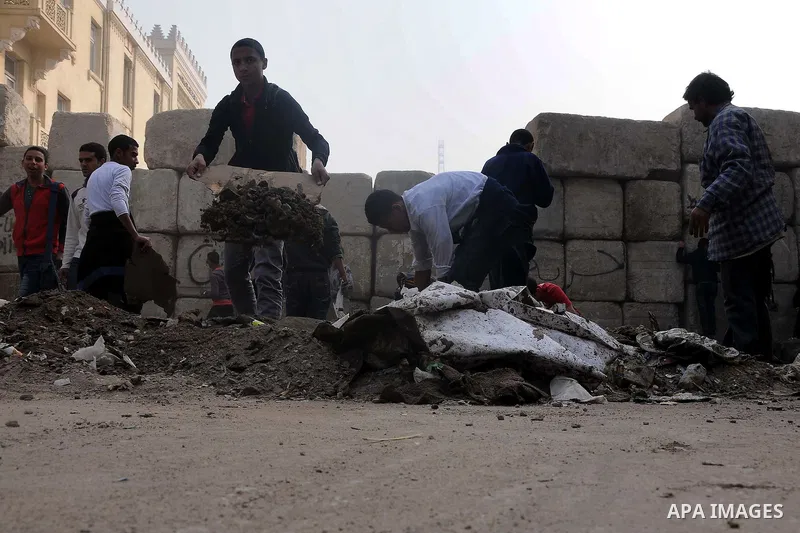 Egyptian protesters gather debris in a street by the Institute of Egypt, which was torched during protests, in central Cairo on December 20, 2011. Clashes between Egyptian security forces and protesters demanding an end...