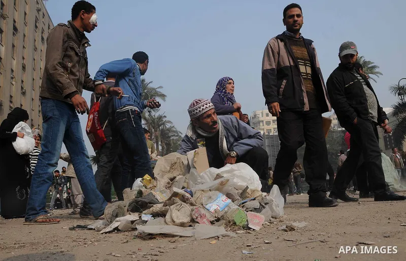 Egyptian protesters gather debris in a street by the Institute of Egypt, which was torched during protests, in central Cairo on December 20, 2011. Clashes between Egyptian security forces and protesters demanding an end...