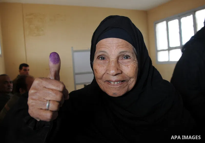 An Egyptian woman shows her ink-stained finger after she voted at a polling station in Giza district near Cairo on December 21, 2011 in the run-off of the second round of legislative election marred by deadly clashes bet...