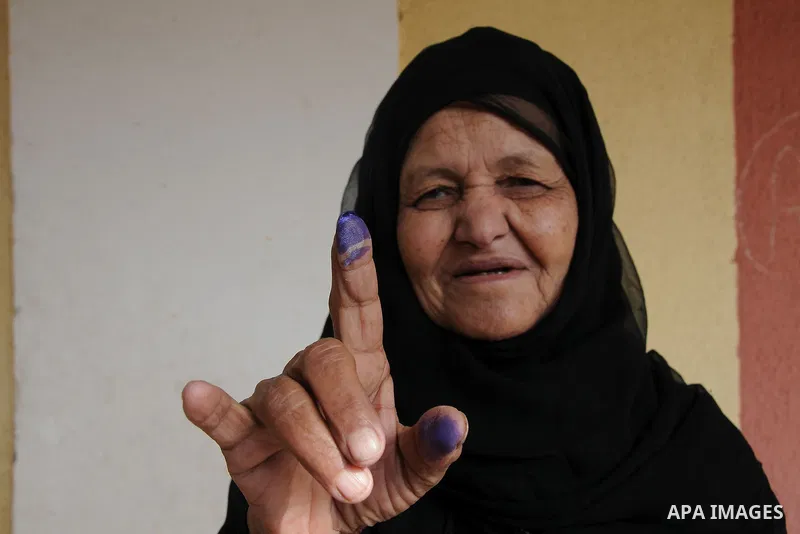 An Egyptian woman shows her ink-stained finger after she voted at a polling station in Giza district near Cairo on December 21, 2011 in the run-off of the second round of legislative election marred by deadly clashes bet...