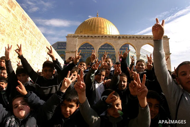 Palestinian school boys sit in front of the Dome of the Rock at Al-Aqsa mosque compound during a school trip in Jerusalem's old city on Dec. 22, 2011. Photo by Mahfouz Abu Turk