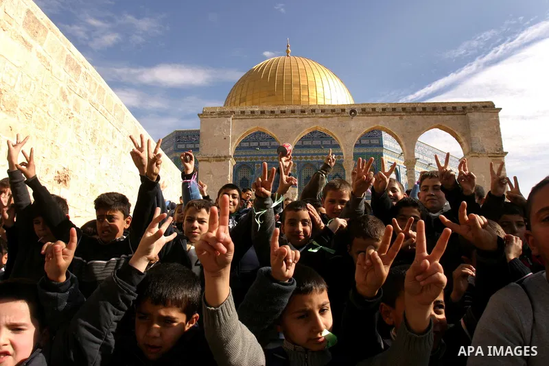 Palestinian school boys sit in front of the Dome of the Rock at Al-Aqsa mosque compound during a school trip in Jerusalem's old city on Dec. 22, 2011. Photo by Mahfouz Abu Turk