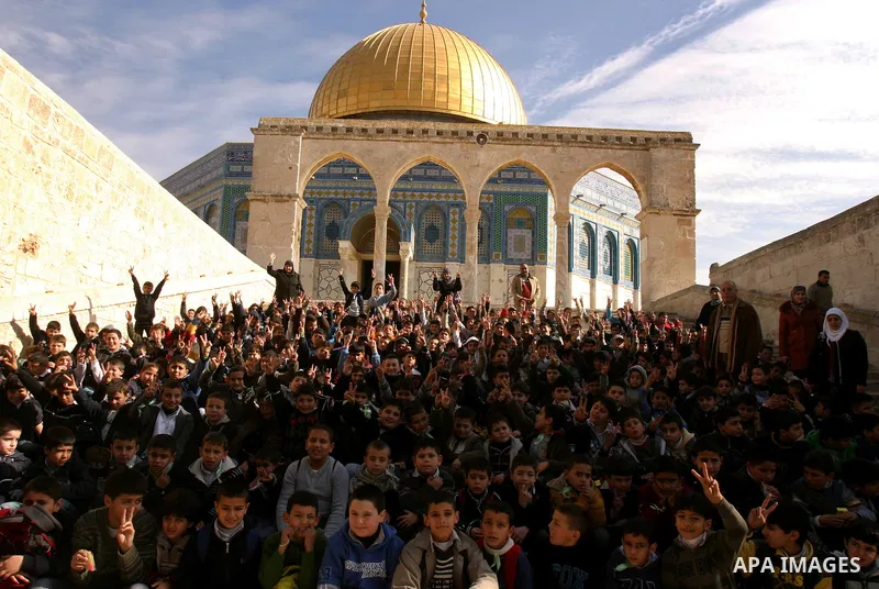 Palestinian school boys sit in front of the Dome of the Rock at Al-Aqsa mosque compound during a school trip in Jerusalem's old city on Dec. 22, 2011. Photo by Mahfouz Abu Turk