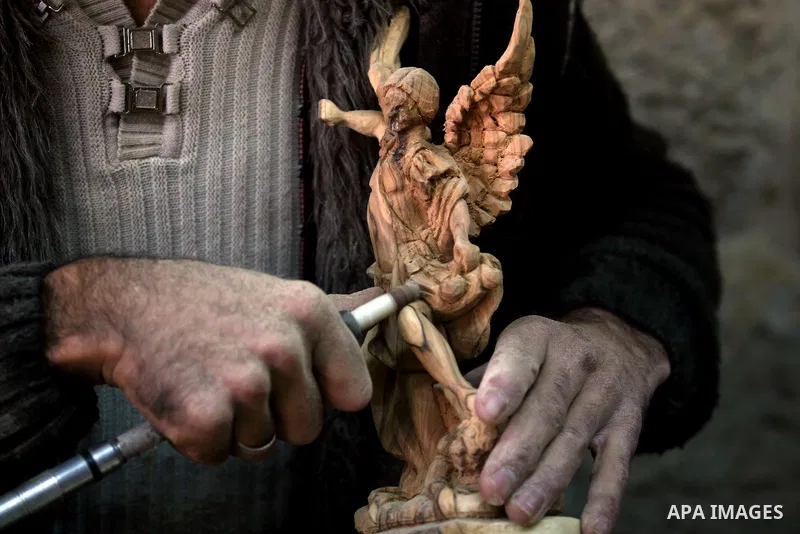 A Palestinian wood carver works on a nativity figurines are stored in an olive wood factory in the West Bank town of Bethlehem, ahead of Christmas,Thursday, Dec. 22, 2011. Photo by Issam Rimawi