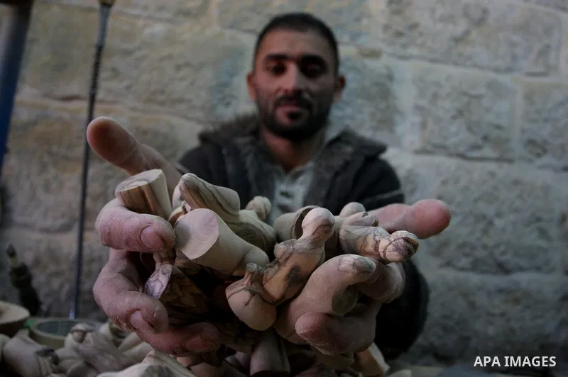 A Palestinian wood carver works on a nativity figurines are stored in an olive wood factory in the West Bank town of Bethlehem, ahead of Christmas,Thursday, Dec. 22, 2011. Photo by Issam Rimawi