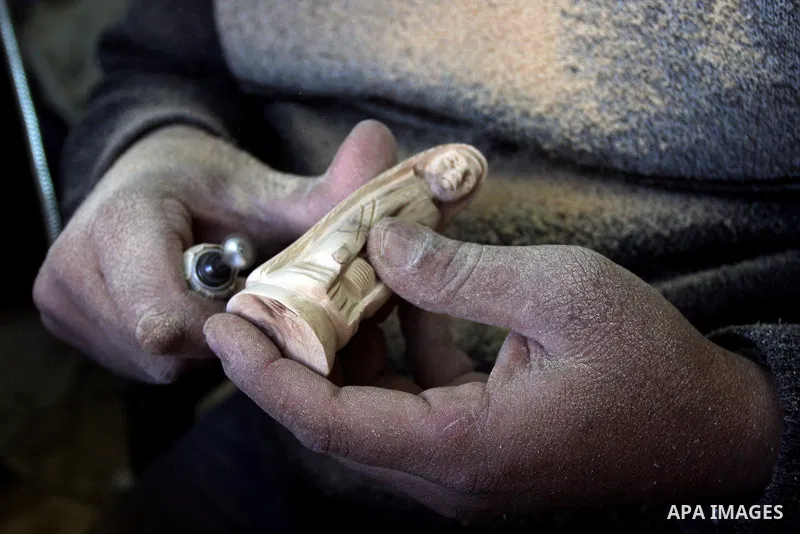A Palestinian wood carver works on a nativity figurines are stored in an olive wood factory in the West Bank town of Bethlehem, ahead of Christmas,Thursday, Dec. 22, 2011. Photo by Issam Rimawi