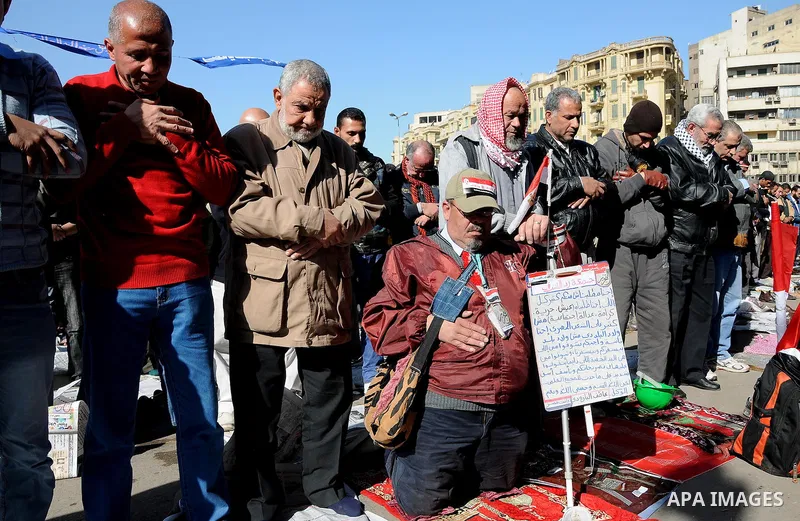 Protesters gather for Friday prayers next to a coffin bearing the national flag, symbolising Egyptians who died in the latest clashes at Tahrir Square, in Cairo December 23, 2011. Thousands of Egyptians rallied in Cairo...
