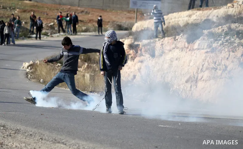 A Palestinian demonstrator hurls tear gas canister towards Israeli security forces during clashes at a weekly protest against a nearby Jewish settlement, in the West Bank village of Nabi Saleh, near Ramallah December 23,...