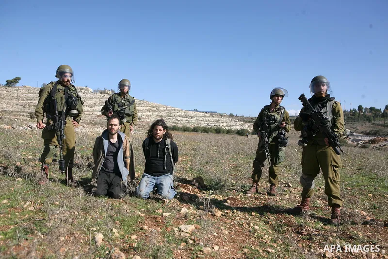 A Palestinian protester is detained by Israeli soldiers during clashes at a weekly protest against a nearby Jewish settlement, in the West Bank village of Nabi Saleh, near Ramallah December 23, 2011. Some 100 demonstrato...