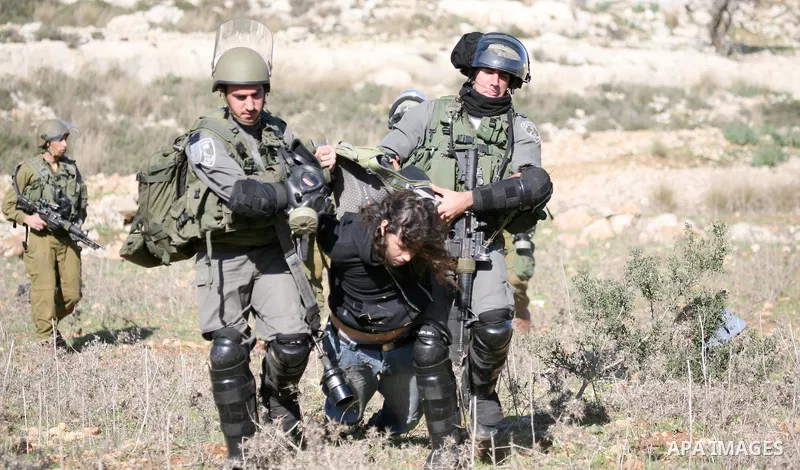 A Palestinian protester is detained by Israeli soldiers during clashes at a weekly protest against a nearby Jewish settlement, in the West Bank village of Nabi Saleh, near Ramallah December 23, 2011. Some 100 demonstrato...