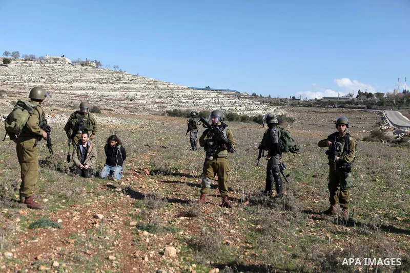 A Palestinian protester is detained by Israeli soldiers during clashes at a weekly protest against a nearby Jewish settlement, in the West Bank village of Nabi Saleh, near Ramallah December 23, 2011. Some 100 demonstrato...