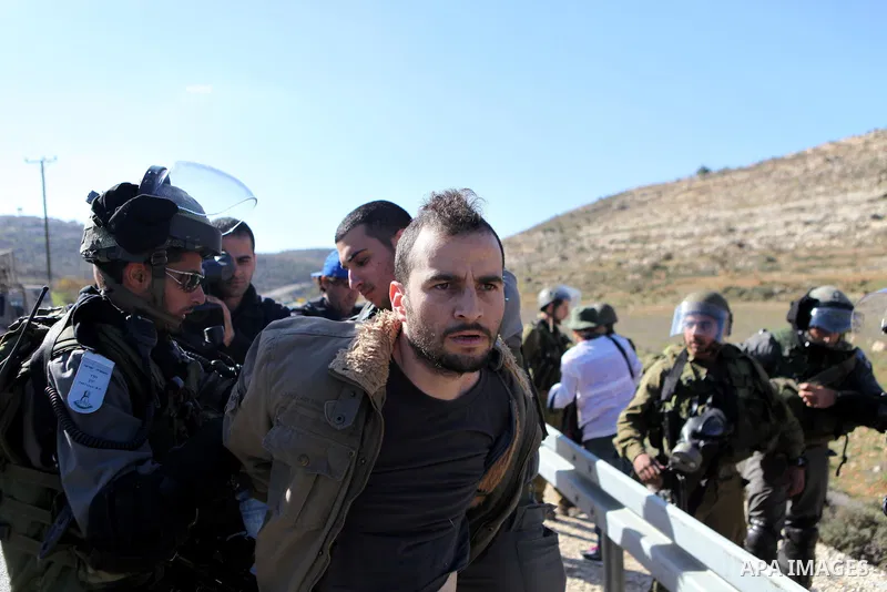 A Palestinian protester is detained by Israeli soldiers during clashes at a weekly protest against a nearby Jewish settlement, in the West Bank village of Nabi Saleh, near Ramallah December 23, 2011. Some 100 demonstrato...