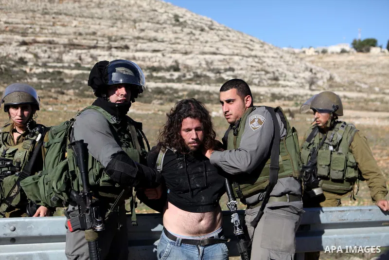 A Palestinian protester is detained by Israeli soldiers during clashes at a weekly protest against a nearby Jewish settlement, in the West Bank village of Nabi Saleh, near Ramallah December 23, 2011. Some 100 demonstrato...