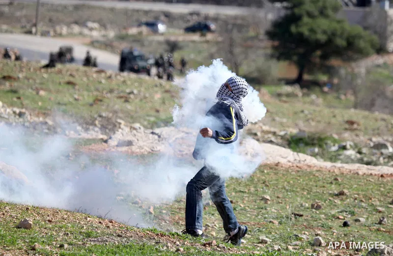 A Palestinian demonstrator hurls tear gas canister towards Israeli security forces during clashes at a weekly protest against a nearby Jewish settlement, in the West Bank village of Nabi Saleh, near Ramallah December 23,...