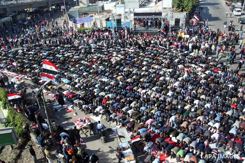Supporters of the Egyptian military hold a giant Egyptian flag during a pro-military rally in Cairo's Abbassiya district on December 23, 2011. Thousands of anti-military protesters gathered in the nearby Tahrir Square to...