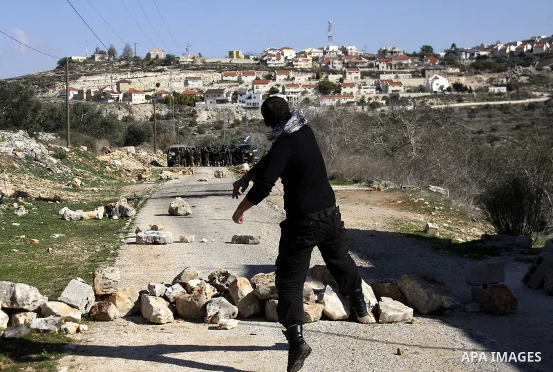 Palestinian youths hurl stones at Israeli security forces ,during a protest in the village of Kufr Qaddum near the Israeli settlement of Kdumim, in the northern West Bank, Friday, Dec. 23, 2011 . Photo by Wagdi Eshtayah.