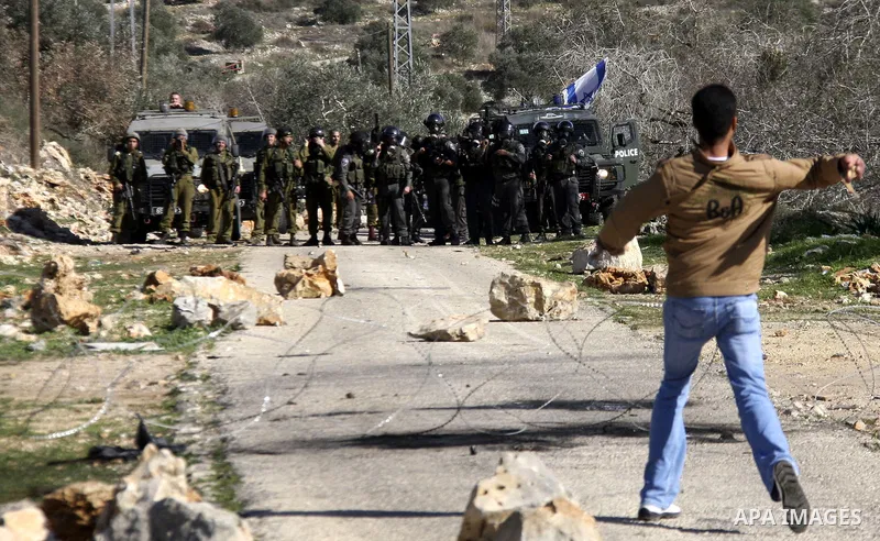 Palestinian youths hurl stones at Israeli security forces ,during a protest in the village of Kufr Qaddum near the Israeli settlement of Kdumim, in the northern West Bank, Friday, Dec. 23, 2011 . Photo by Wagdi Eshtayah.