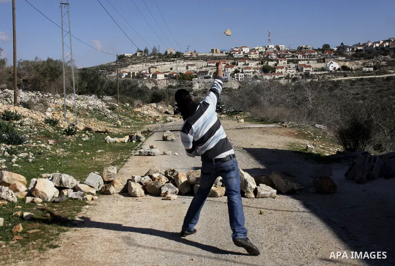 Palestinian youths hurl stones at Israeli security forces ,during a protest in the village of Kufr Qaddum near the Israeli settlement of Kdumim, in the northern West Bank, Friday, Dec. 23, 2011 . Photo by Wagdi Eshtayah.