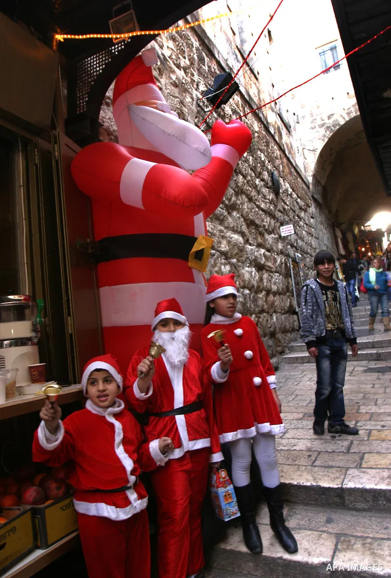 A Palestinian boy dressed-up in a Santa Claus costume walks on Jerusalem's Old City walls on December 24, 2011. Photo by Mahfouz Abu Turk