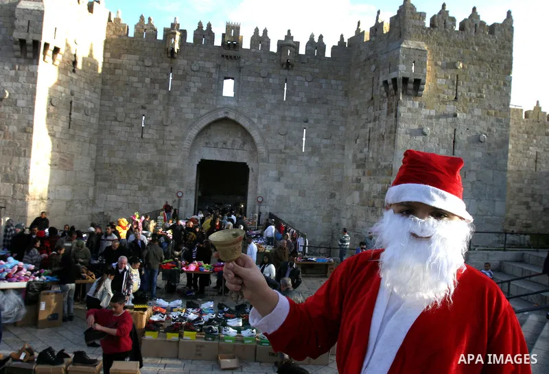 A Palestinian boy dressed-up in a Santa Claus costume walks on Jerusalem's Old City walls on December 24, 2011. Photo by Mahfouz Abu Turk