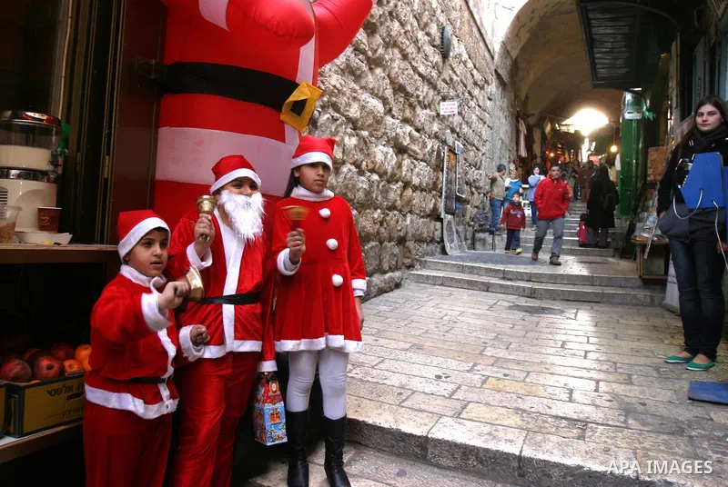 A Palestinian boys dressed-up in a Santa Claus costume walks on Jerusalem's Old City walls on December 24, 2011. Photo by Mahfouz Abu Turk