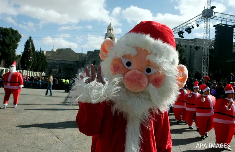 A person dressed as Santa Claus rings a bell during celebrations for Christmas near the Church of the Nativity in West Bank town of Bethlehem December 24, 2011. Photo by Issam Rimawi