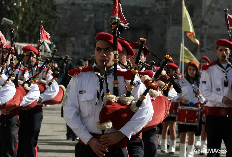 Palestinian Scouts play the bagpipes outside the Church of the Nativity while Christians gather for Christmas celebrations in the West Bank city of Bethlehem on December 24, 2011, as thousands of Christian pilgrims desce...