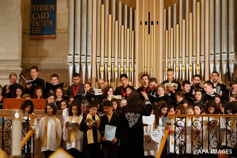Members of Hungarian Saint Angela choir sing during the Christmas midnight Mass at the Church of the Nativity, traditionally believed to be the birthplace of Jesus Christ, in the West Bank town of Bethlehem early Sunday,...