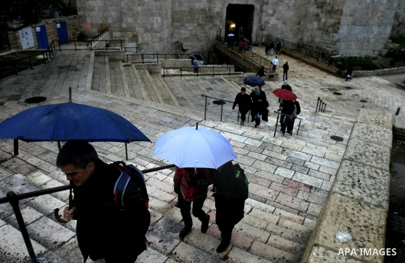 Palestinians walk outside Damascus Gate leading into the old city of Jerusalem from their way from prayer in the Al-Aqsa Mosque compound, Islam's third holiest site, on Dec 25, 2011. Photo by Mahfouz Abu Turk