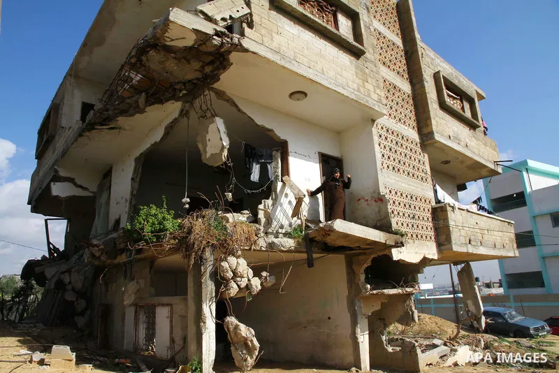Palestinian woman stands in her house destroyed during the three-week offensive Israel launched before three years, in Gaza City, on 26 December 2011. which was damaged during Israel's three-week offensive three years ag...
