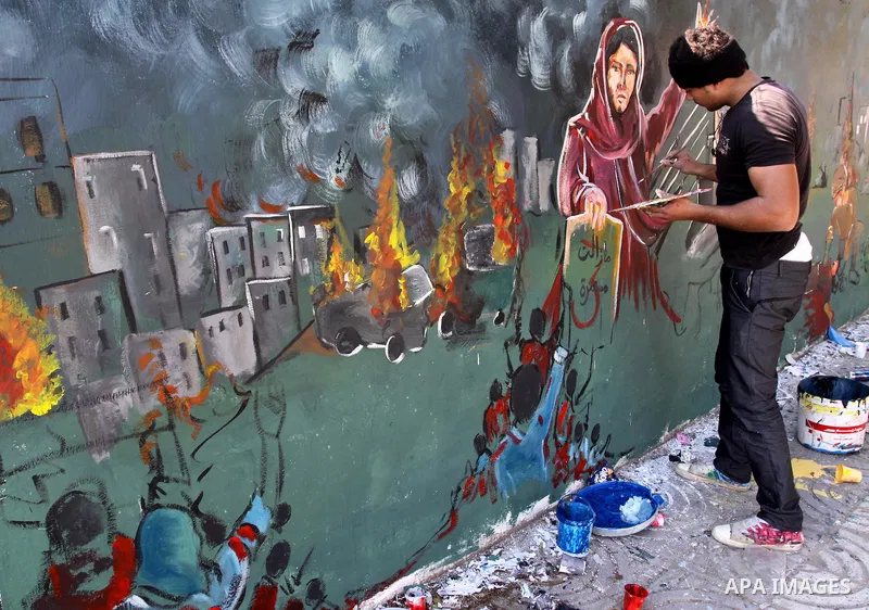 Palestinian Artists take part in paint a murals in the third anniversary of the Israeli war on Gaza Strip, in Gaza city on Dec. 27,2011. Photo by Mohammed Asad