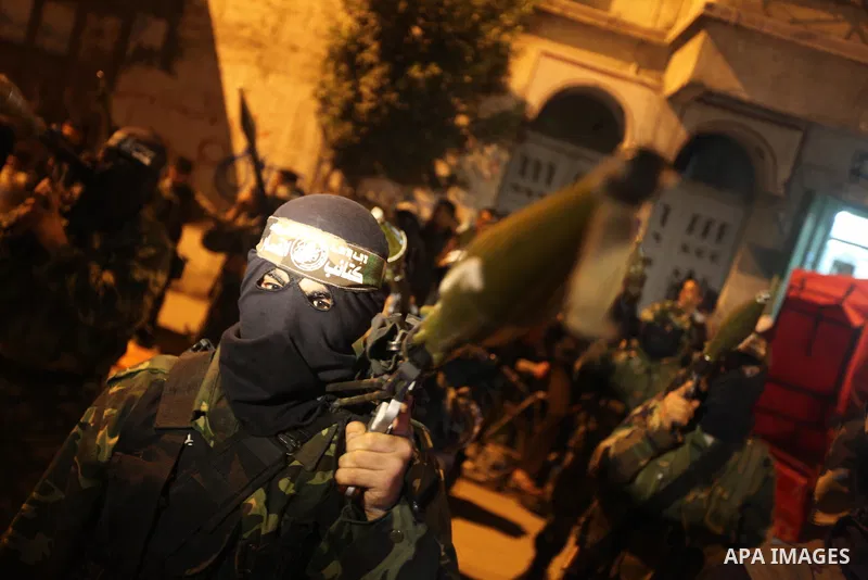 Masked Hamas militants march with their guns during a parade to mark the third anniversary of the Israeli offensive on Gaza in 2008, in Gaza City, Tuesday, Dec. 27, 2011. Palestinians mark the third anniversary of the th...