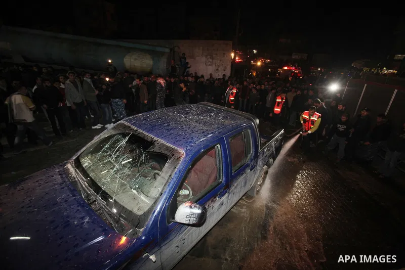 Palestinians gather around a vehicle targeted in a second Israeli air strike in Gaza City on December 27, 2011. Photo by Ali Jadallah