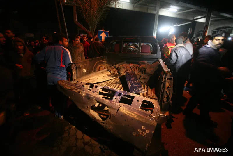 Palestinians gather around a vehicle targeted in a second Israeli air strike in Gaza City on December 27, 2011. Photo by Ali Jadallah