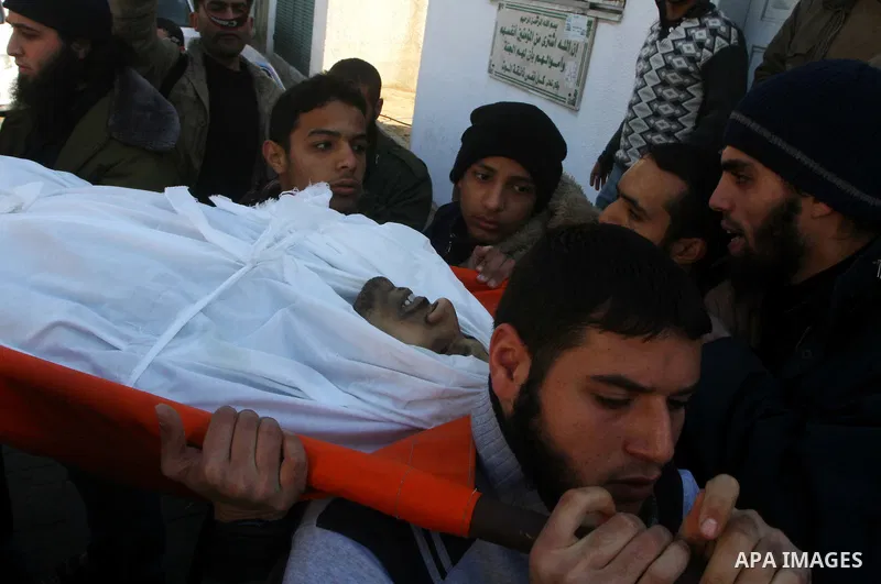Palestinian mourners carry the body of Abdallah al-Telbani, 22-years-old, during his funeral in Gaza City on December 28, 2011, after he was killed following an Israeli airstrike. Photo by Ashraf Amra