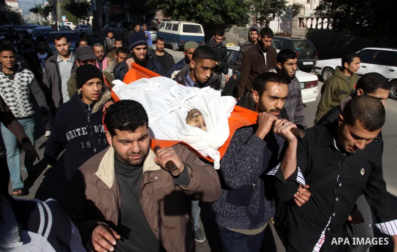 Palestinian mourners carry the body of Abdallah al-Telbani, 22-years-old, during his funeral in Gaza City on December 28, 2011, after he was killed following an Israeli airstrike. Photo by Mohammed Asad