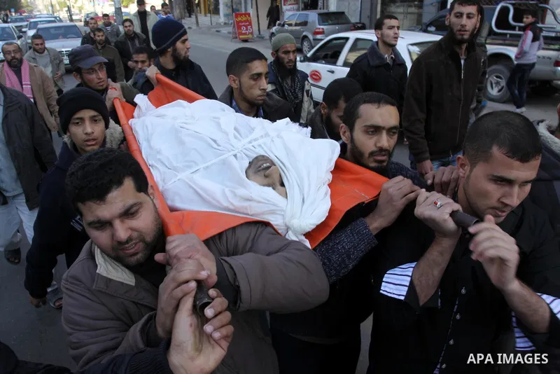 Palestinian mourners carry the body of Abdallah al-Telbani, 22-years-old, during his funeral in Gaza City on December 28, 2011, after he was killed following an Israeli airstrike. Photo by Mohammed Asad