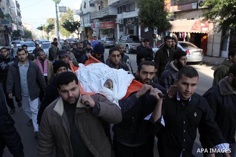 Palestinian mourners carry the body of Abdallah al-Telbani, 22-years-old, during his funeral in Gaza City on December 28, 2011, after he was killed following an Israeli airstrike. Photo by Mohammed Asad