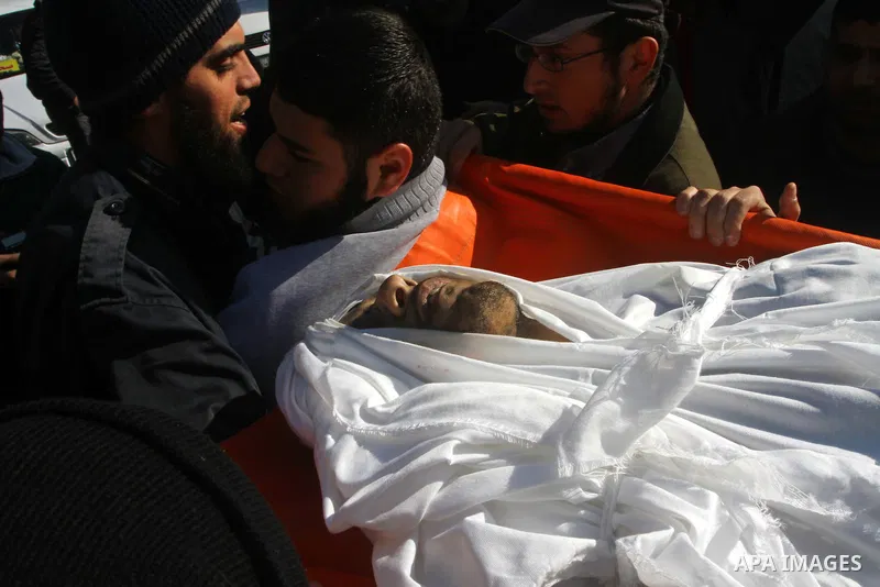 Palestinian mourners carry the body of Abdallah al-Telbani, 22-years-old, during his funeral in Gaza City on December 28, 2011, after he was killed following an Israeli airstrike. Photo by Ashraf Amra