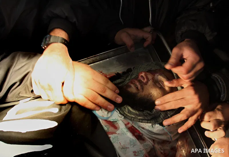 Palestinians look at the body of militant Momen Abu Daf during his funeral at a mosque in Gaza City December 30, 2011. Israel killed the leader of an al Qaeda-inspired faction in the Gaza Strip on Friday, accusing him of...