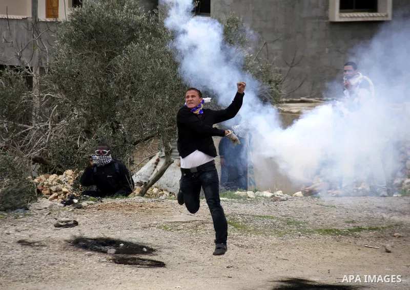A Palestinian protester hurls stones at Israeli soldiers during a protest against the Jewish settlement of Qadomem, near the West Bank City of Nablus on 30 December 2011. Seven Palestinians were wounded during the clashe...