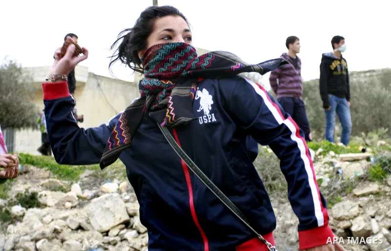 A Palestinian protester hurls stones at Israeli soldiers during a protest against the Jewish settlement of Qadomem, near the West Bank City of Nablus on 30 December 2011. Seven Palestinians were wounded during the clashe...