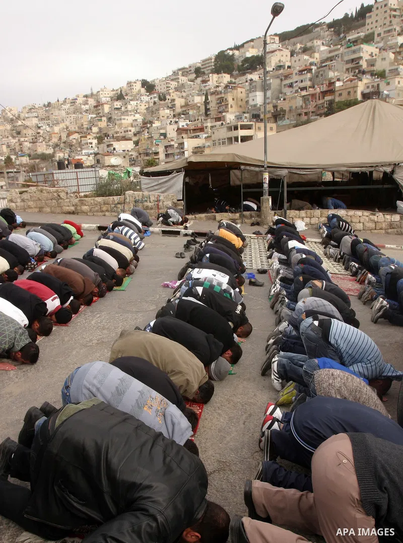 Palestinian Muslims attend Friday prayers at a street in the neighbourhood of shiek Jarah , in East Jerusalem on Dec 30,2011. Israel limited access to Jerusalem's Al-Aqsa mosque compound for fear of violence on the Musli...