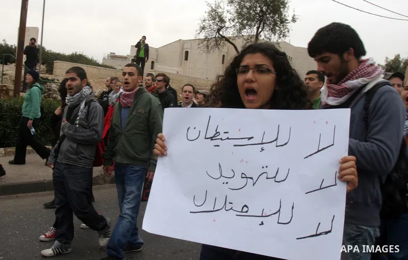 Palestinian arab residents of east Jerusalem, Israelis and foreign peace activists hold banners during a protest in the east Jerusalem neighborhood of Sheikh Jarrah, Dec 30, 2011. Photo by Mahfouz Abu Turk
