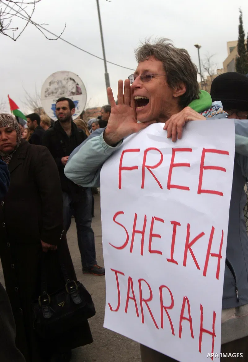 Palestinian arab residents of east Jerusalem, Israelis and foreign peace activists hold banners during a protest in the east Jerusalem neighborhood of Sheikh Jarrah, Dec 30, 2011. Photo by Mahfouz Abu Turk