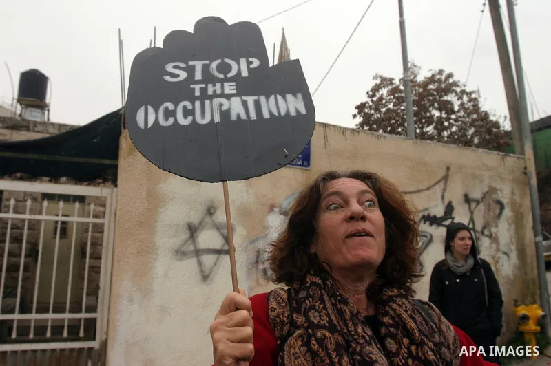 Palestinian arab residents of east Jerusalem, Israelis and foreign peace activists hold banners during a protest in the east Jerusalem neighborhood of Sheikh Jarrah, Dec 30, 2011. Photo by Mahfouz Abu Turk