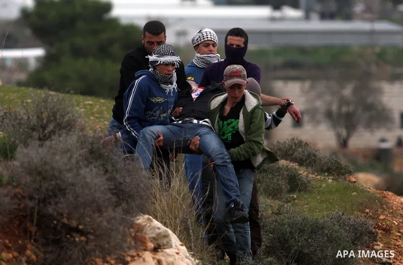 Palestinian protesters runs for cover from tear gas fired by Israeli soldiers during during demonstration against the expansion of the nearby Jewish settlement of Halamish in the West Bank village of Nabi Saleh near Rama...
