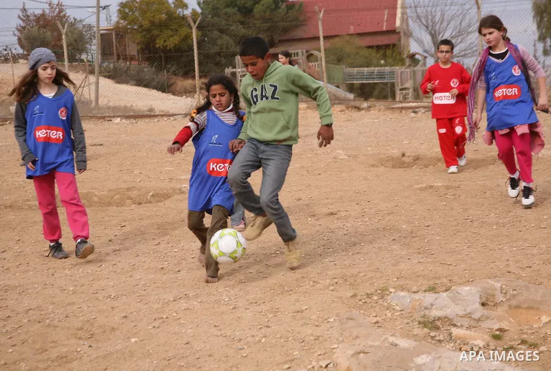 Israeli children from Kibbutz Harel (blue jerseys) play football with Palestinian children in the Umm al-Kheir village, near the West Bank city of Hebron, on December 30, 2011. Photo by Mamoun Wazwaz