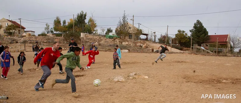 Israeli children from Kibbutz Harel (blue jerseys) play football with Palestinian children in the Umm al-Kheir village, near the West Bank city of Hebron, on December 30, 2011. Photo by Mamoun Wazwaz